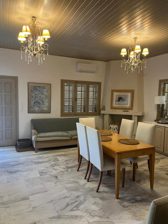 a dining room with a table and chairs at Olive House near the sea in Kharokopión