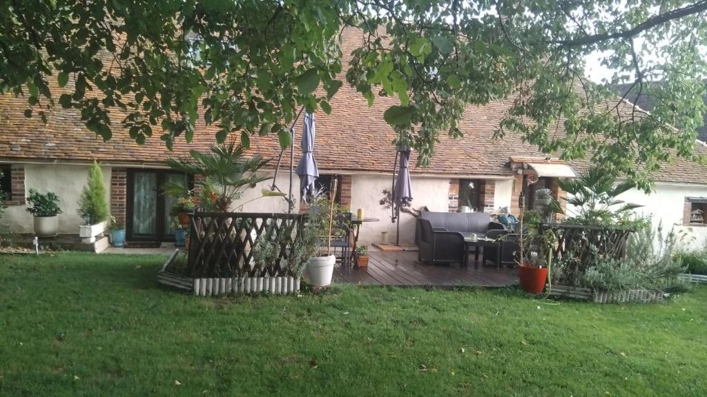 a house with a wooden deck in the yard at LE VIEIL HERMITAGE in Ervauville