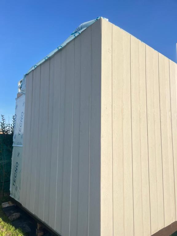a white shipping container sitting next to a building at Casa Acantilados Suites in Mar del Plata
