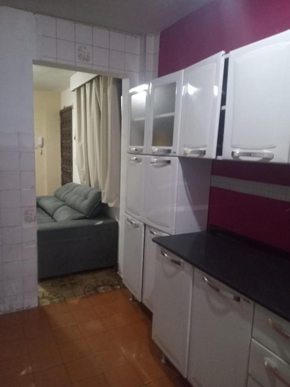 a kitchen with white cabinets and a couch in a room at A 5 minutos de caminhada da Expo Center Norte in Sao Paulo