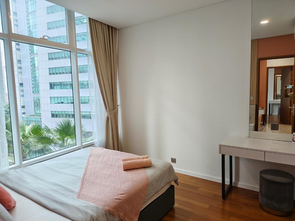 une chambre avec un lit et une grande fenêtre dans l'établissement Sky Suites KLCC Apartment by Family Room Stay, à Kuala Lumpur