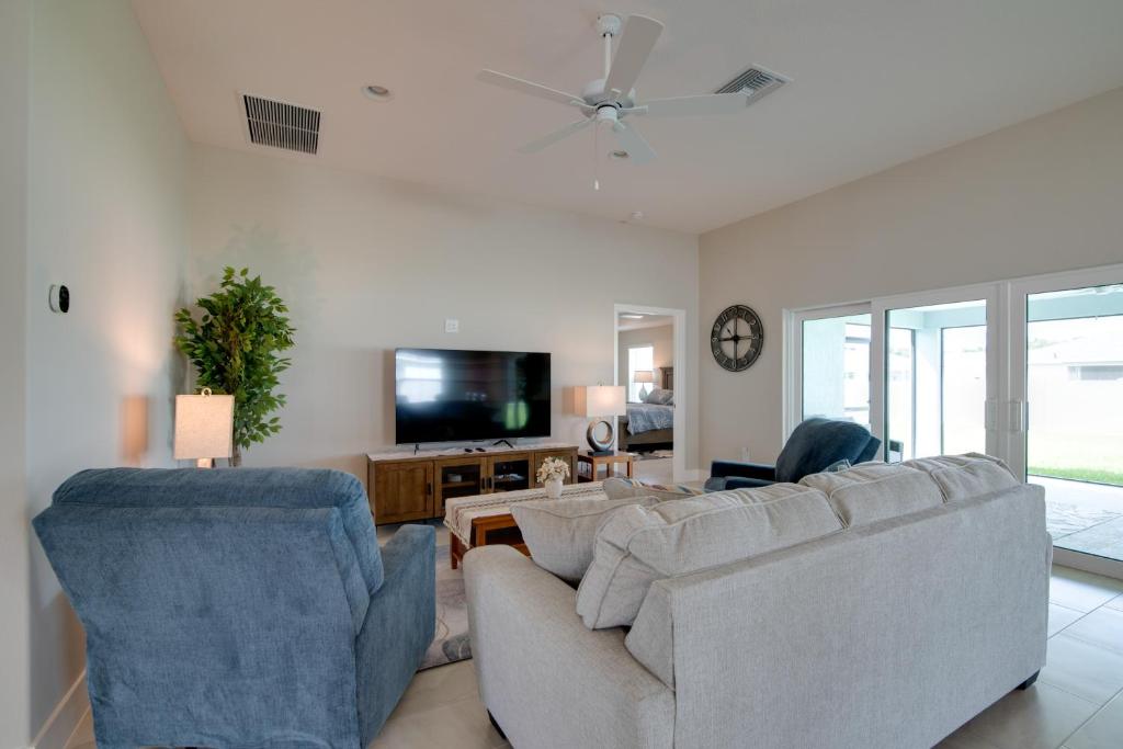 a living room with two couches and a tv at Golf and Swim in The Villages! Modern Home with Lanai in Wildwood