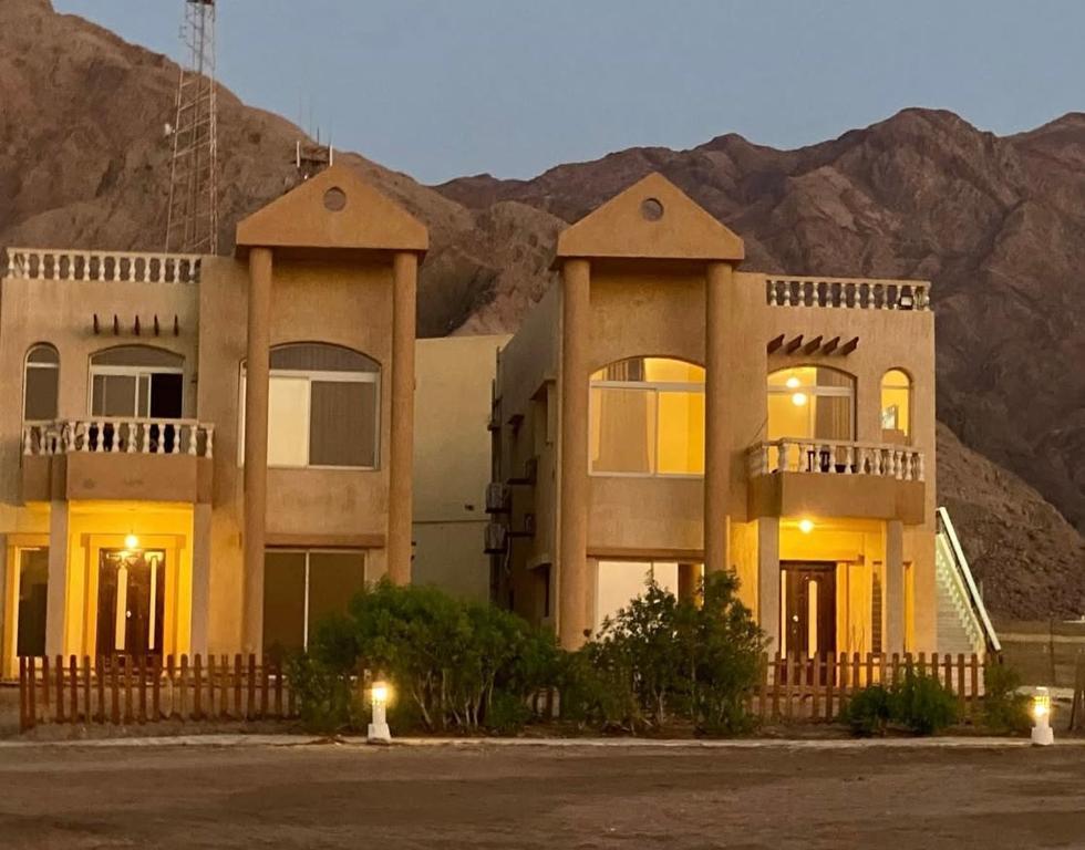 a large building with a mountain in the background at Blue view villas in Dahab