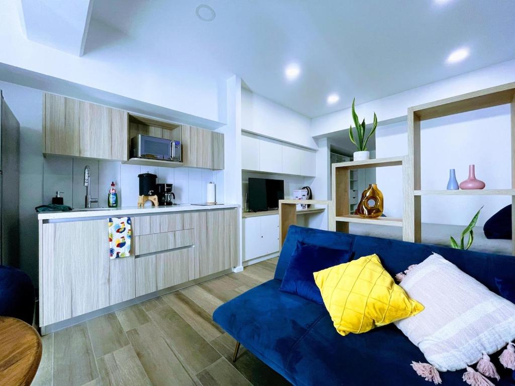 a living room with a blue couch and a kitchen at Apartamento comodo cerca del aeropuerto in Estación Pamplona