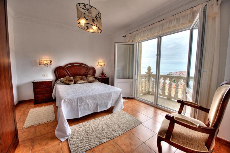 1 dormitorio con cama y ventana grande en Pensión Mirador Fin da Terra en Finisterre
