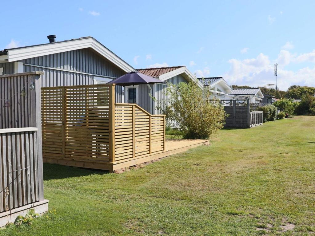 een huis met een houten hek in een tuin bij Beach holiday home in Falkenberg in Falkenberg