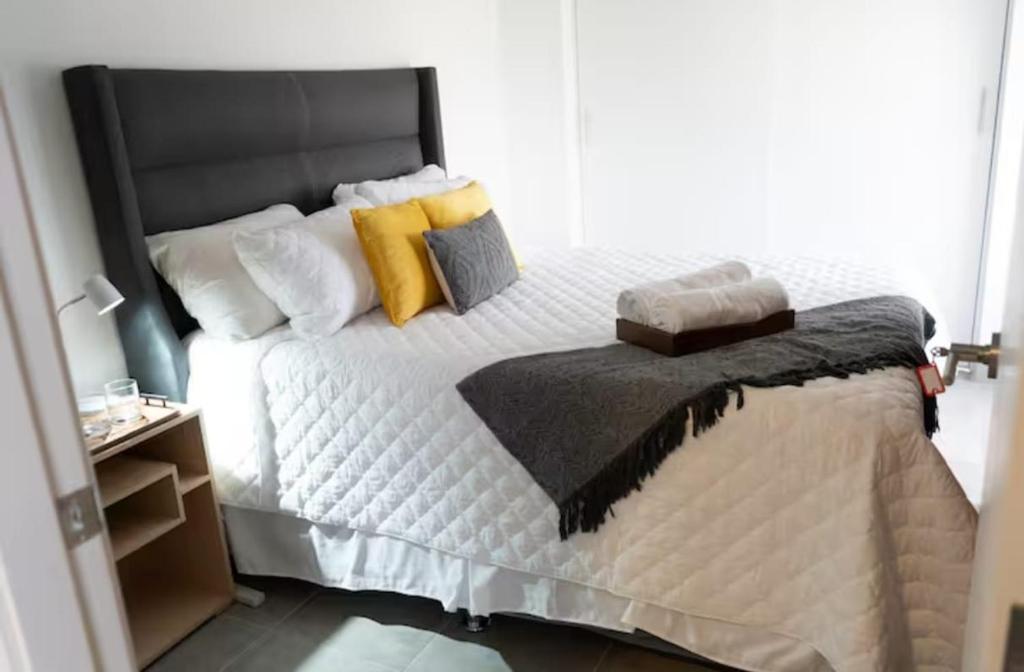 a bedroom with a white bed with yellow pillows at Uleu Zona Viva in Guatemala