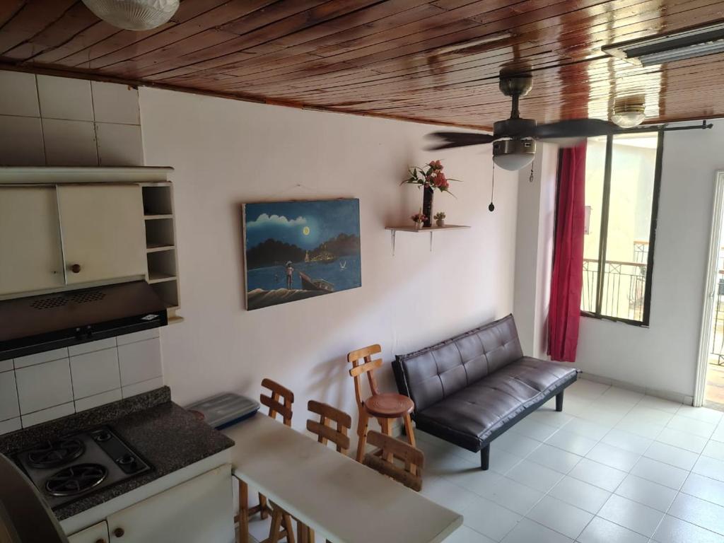 a living room with a leather couch and a kitchen at A pasos del mar en El Rodadero, escape perfecto in Santa Marta