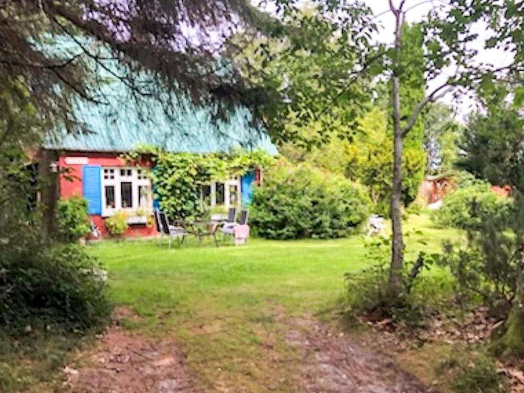 a small house with a blue roof in a yard at 6 person holiday home in Brædstrup-By Traum in Brædstrup