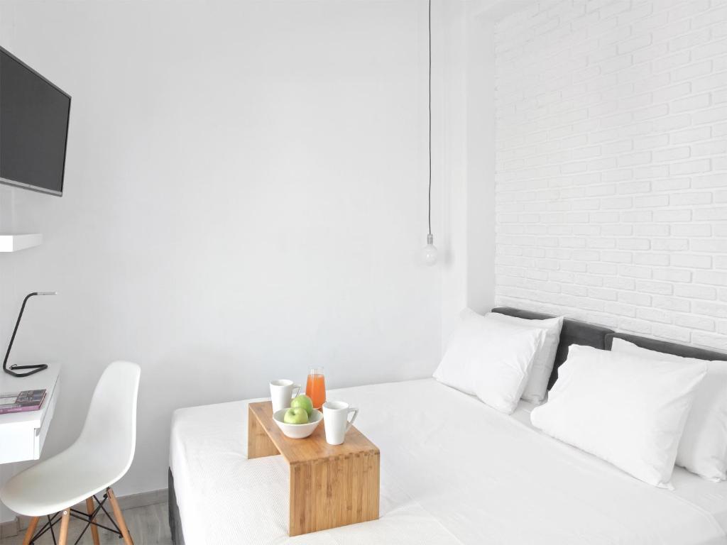 - une chambre blanche avec un lit et un plateau en bois dans l'établissement Athens View Loft - 05, à Athènes