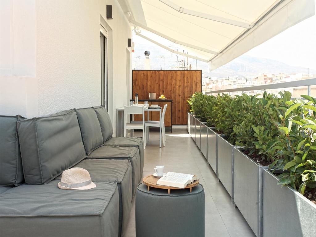 a couch and a table on a balcony with plants at Athens View Loft - 06 in Athens