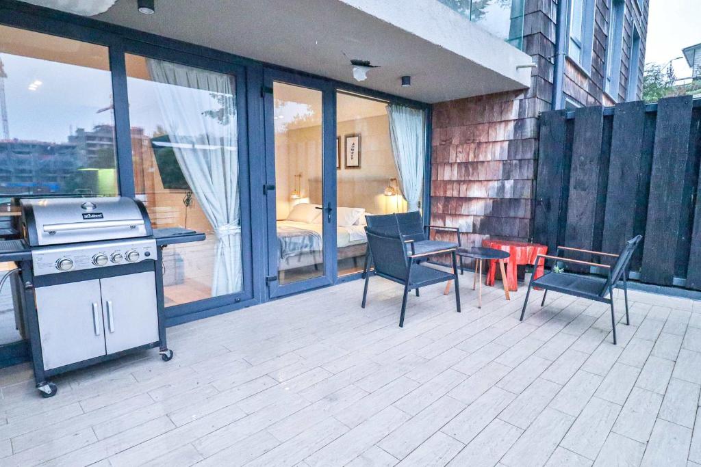 a patio with a grill and a table and chairs at HOM I Depto con Gran Terraza con Vista al Lago in Puerto Varas