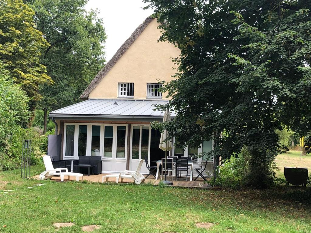 ein Haus mit einem Tisch und Stühlen im Hof in der Unterkunft Gîte cosy près de Guérande avec Wi-Fi et terrasse - FR-1-306-1316 in Guérande