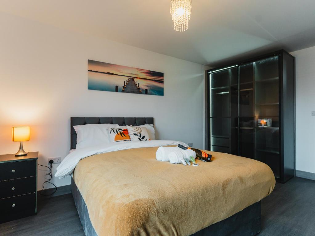 a bedroom with a large bed with a white dog on it at Leicestershire Aparthotels - Field Street Court in Shepshed