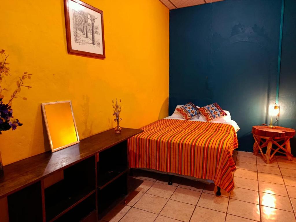 Un dormitorio con una cama y un escritorio con espejo. en Expresión cultural restaurante y alojamiento, en Santa Ana