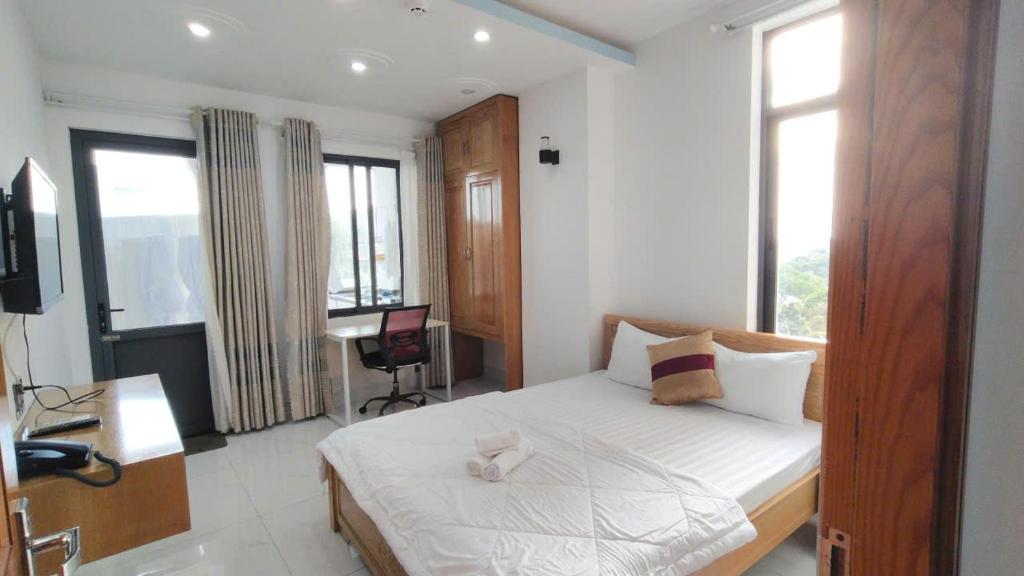 - une chambre avec un lit blanc, un bureau et une fenêtre dans l'établissement HomeStay Khánh Linh B1 Hồ Quý Ly, à Vung Tau