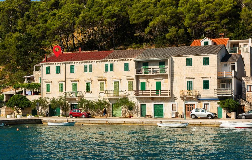 a large building next to a body of water at Three-Bedroom Apartment In Povlja in Povlja