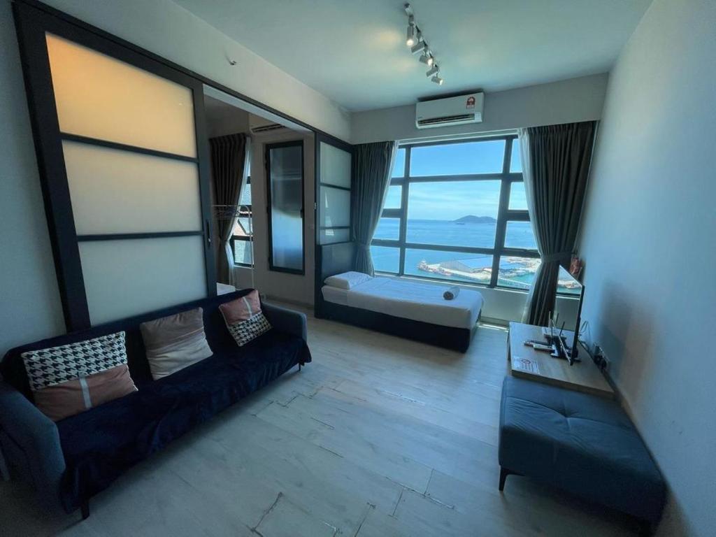 a living room with a couch and a large window at Jesselton Quay Kota Kinabalu City Centre by LW Suites in Kota Kinabalu
