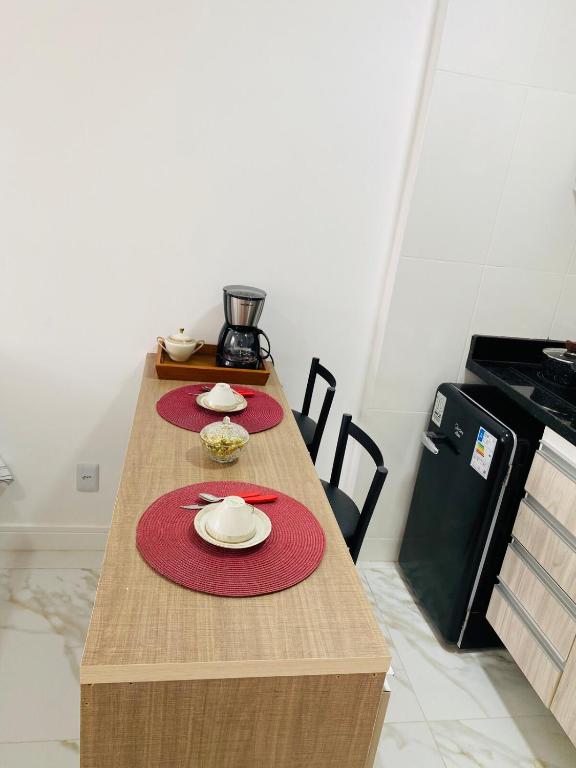 a table with two red placemats on top of it at Território Afeto Odara in Rio de Janeiro