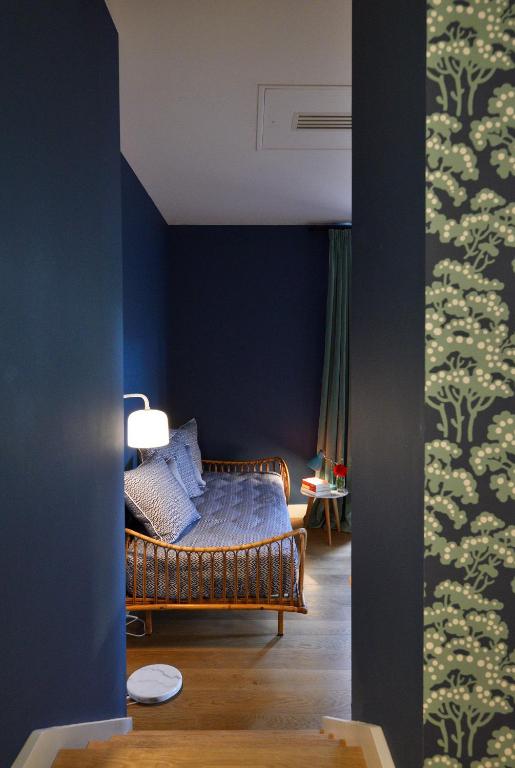 a bedroom with a bed with a blue wall at Hôtel Le Saint Christophe in La Baule