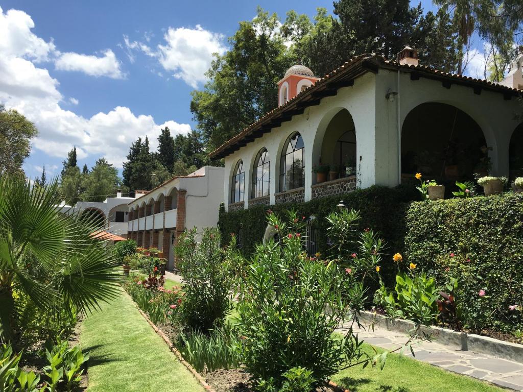 a house with a garden in front of it at Rancho Hotel Atascadero in San Miguel de Allende