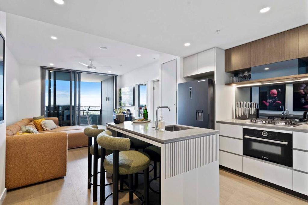 a kitchen with a bar and a living room at Queens Wharf Luxe Retreat -Brisbane CBD, Pool, Spa in Brisbane