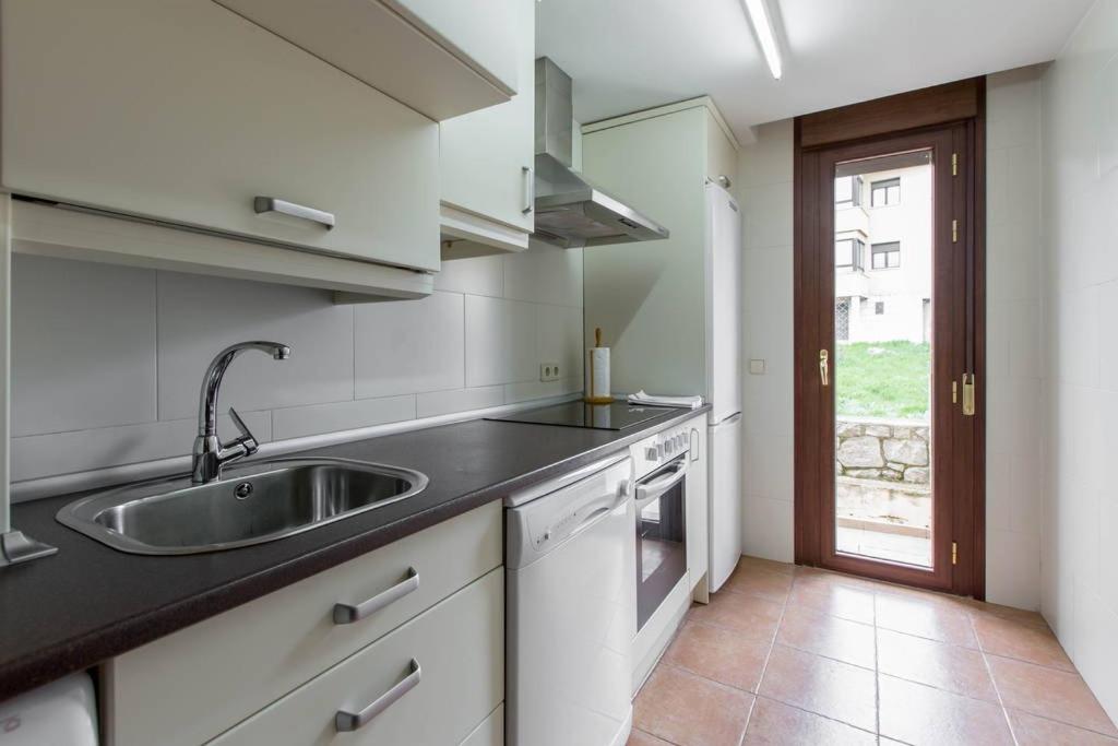 una cocina con fregadero y encimera en Alojamientos Botica Rural, en La Cabrera