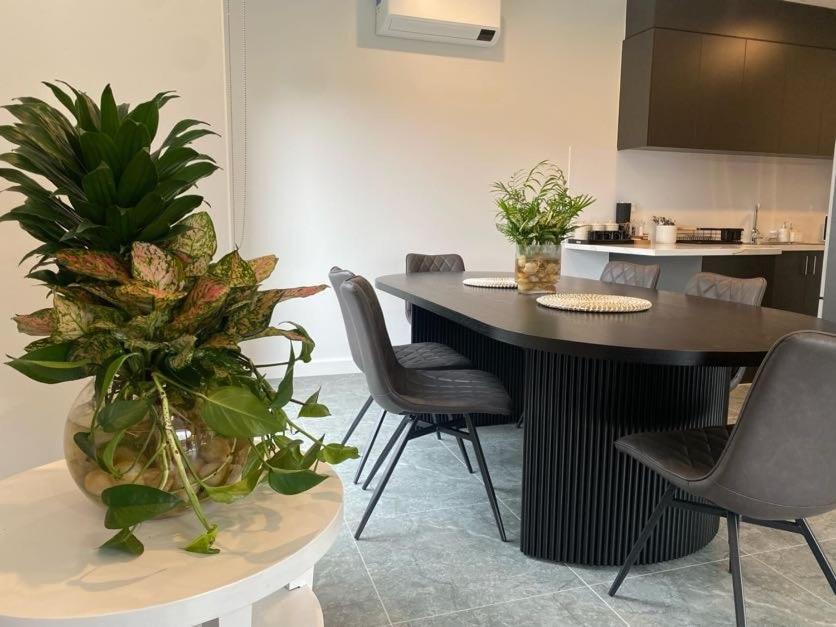 a kitchen with a table with chairs and plants at Springvale Family Friendly Home Best Location in Springvale