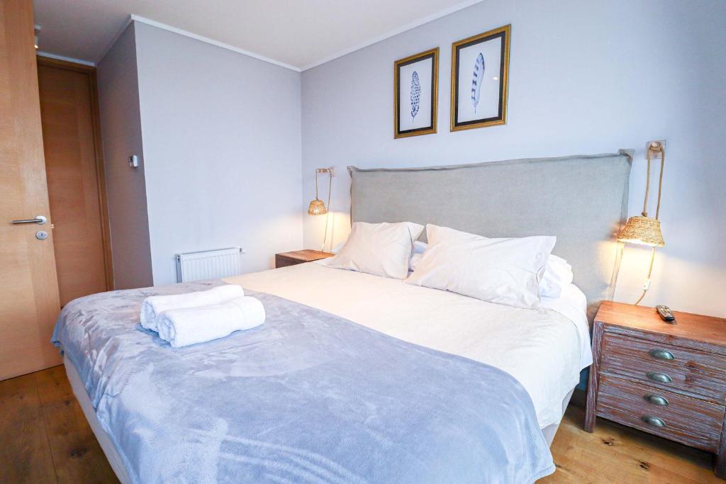 una camera da letto con un letto grande con due asciugamani sopra di HOM I Depto TOP1 con Estacionamiento en Puerto Varas a Puerto Varas