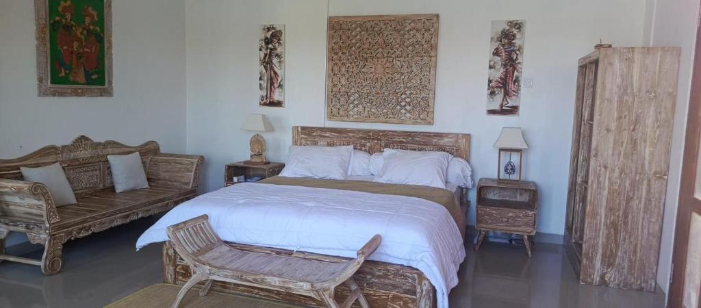 a bedroom with a large bed and a chair at Padma Laya Private Villa 2BR in Sukawati