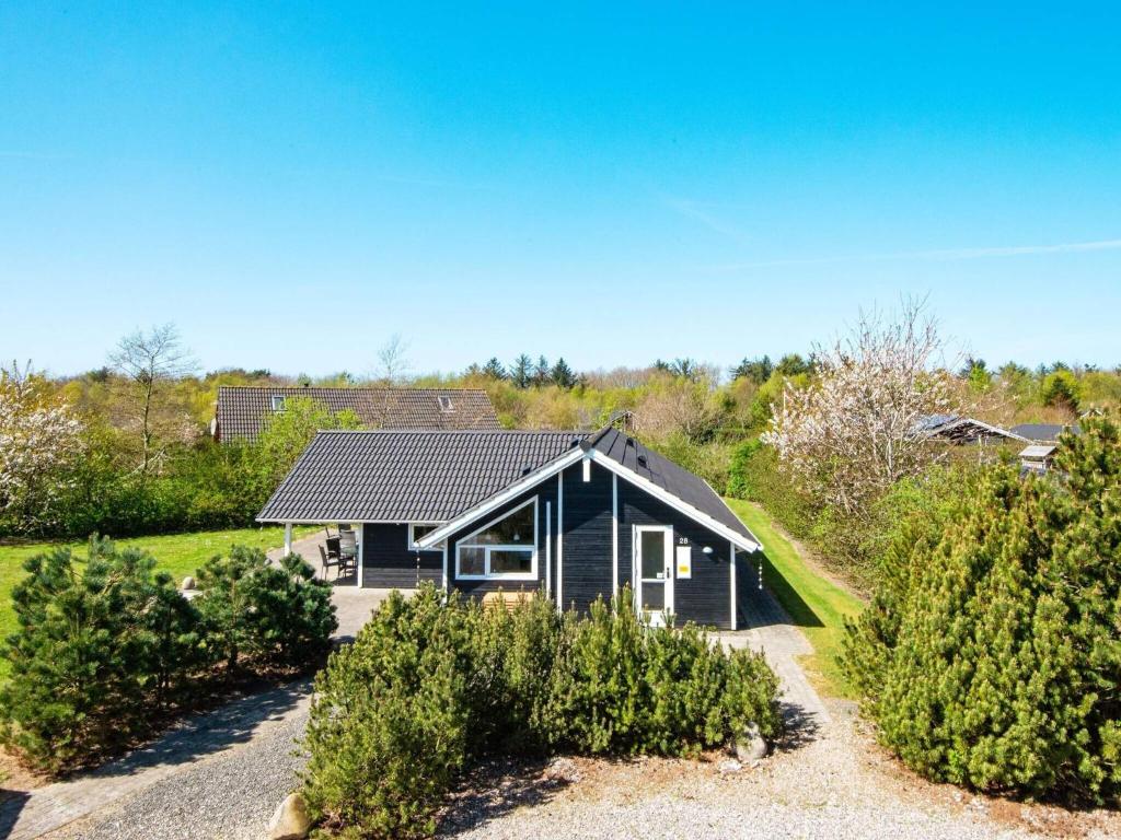 a small black house with bushes in front of it at Luxury Retreat with Spa - By Traum Ferienwohnungen in Hemmet