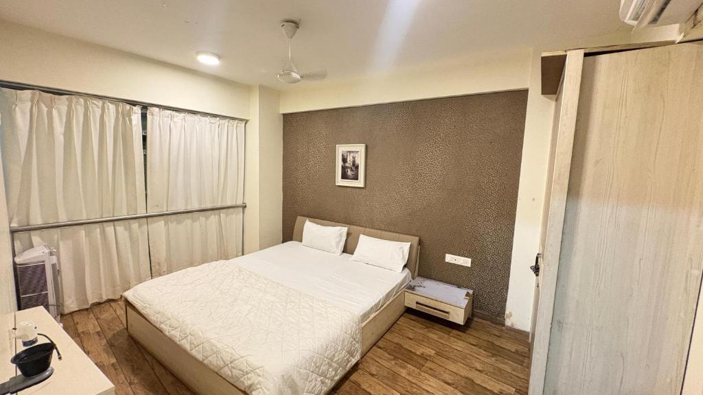 a small bedroom with a bed and a desk at 7 Star homes at Rajhans Belliza in Surat