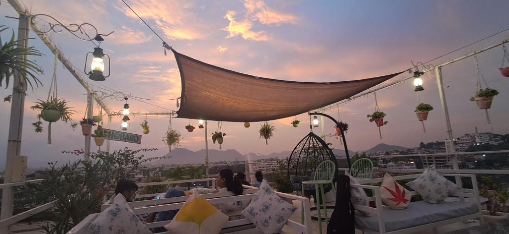 ウダイプールにあるRaahi Backpacker's Hostelのライトと植物が飾られた屋上パティオ