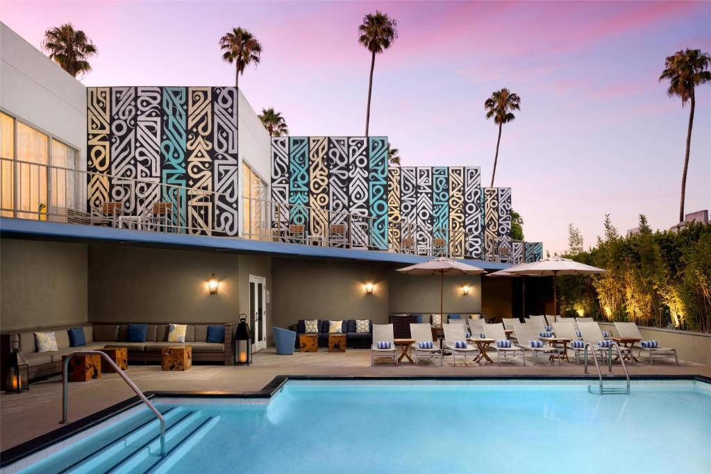 un complejo con piscina y un edificio con palmeras en Hyatt Centric Delfina Santa Monica, en Los Ángeles