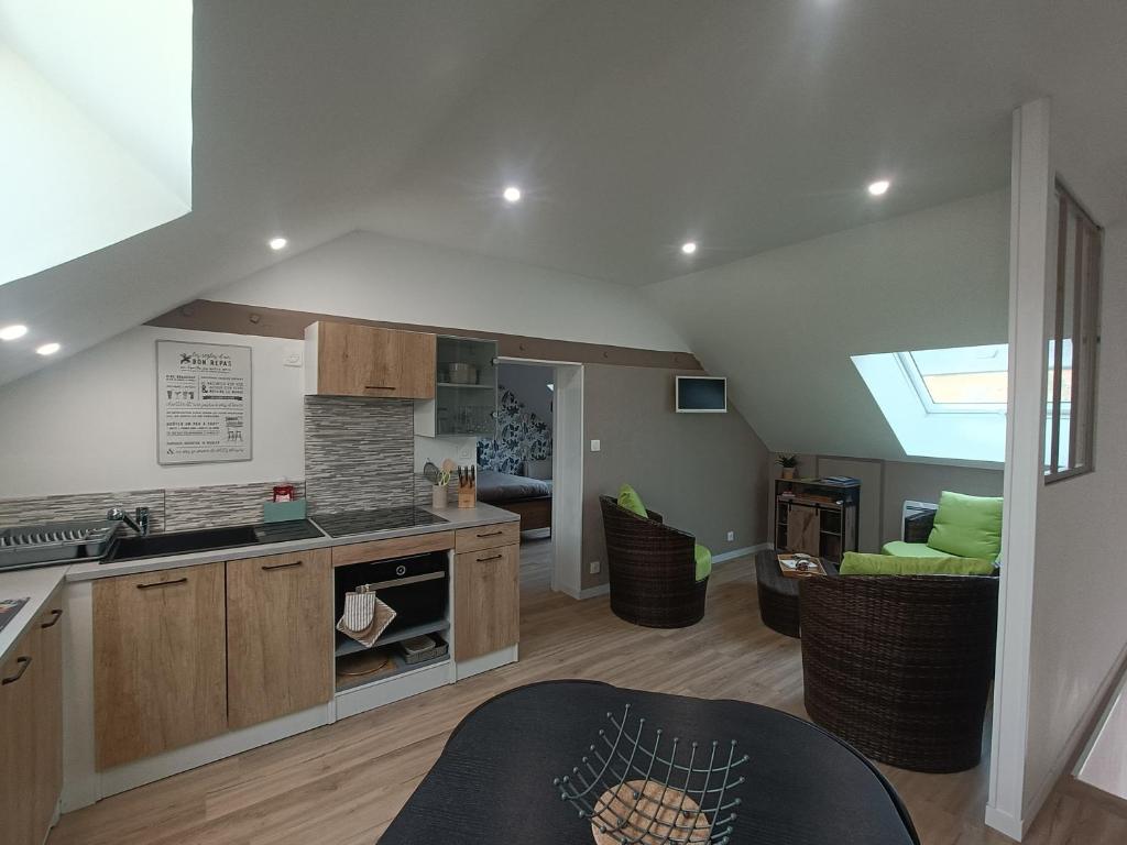 an open kitchen and living room with a skylight at Les caves Sainte Anne Ecommoy 72220 in Écommoy