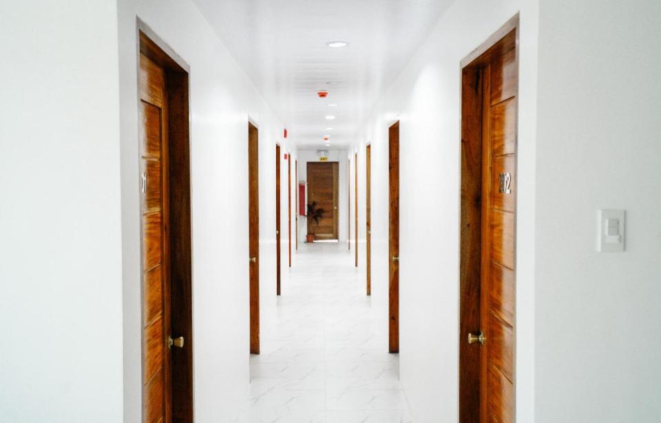 een hal met witte muren en houten deuren bij MGM tourist Inn in Tagbilaran-stad
