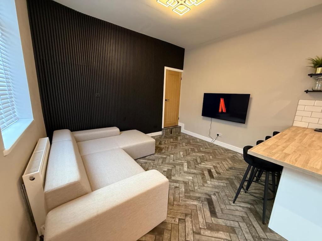 a living room with a couch and a table at Modern 3 Bedroom house, short walk to train station and town centre, close to Manchester Airport and PLouise in Stockport