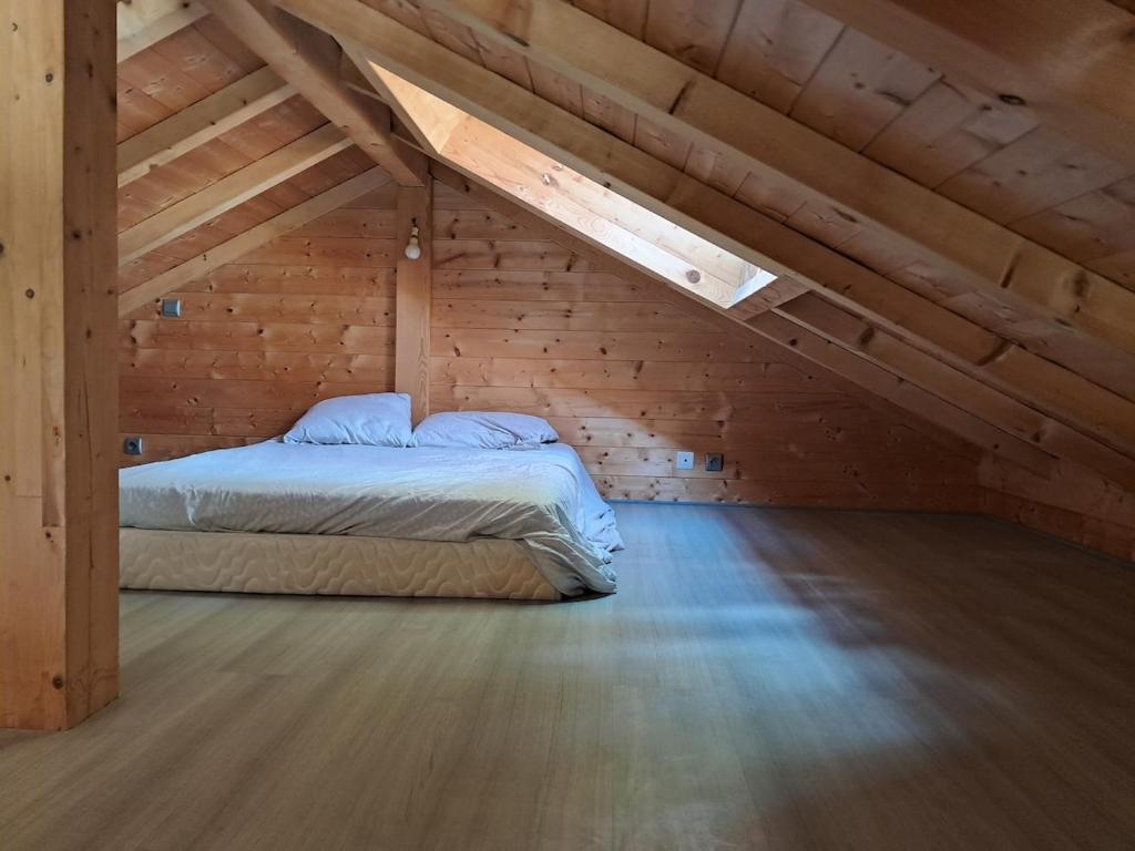 - une chambre avec un lit dans un grenier en bois dans l'établissement Gîte Les Balcons des usses, à Frangy