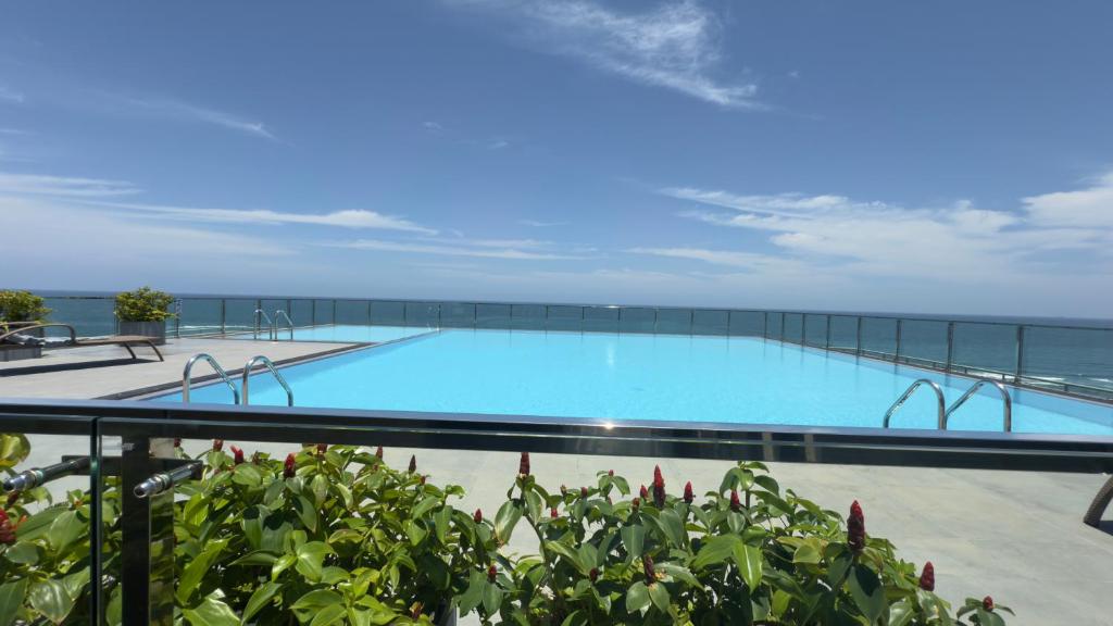 una grande piscina con l'oceano sullo sfondo di Sea View Apartment in Colombo -Dehiwala a Dehiwala