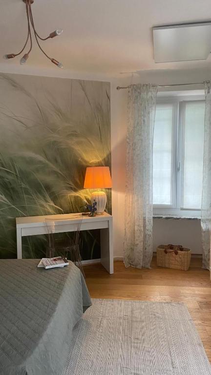 a bedroom with a bed and a desk and a window at Casa Cri in Mondovì