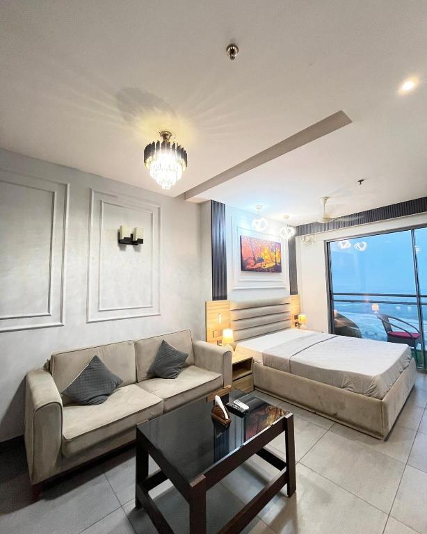 a living room with a couch and a bed at Elite Comfort Stay in Noida