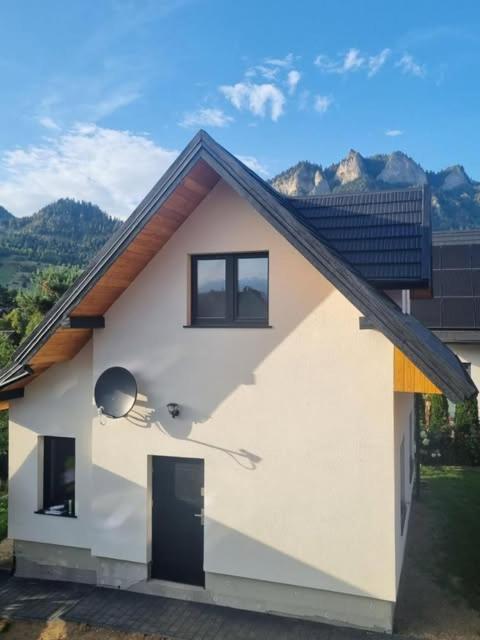 a small white house with a window and a door at Willa Gazda Apartamenty in Sromowce Niżne