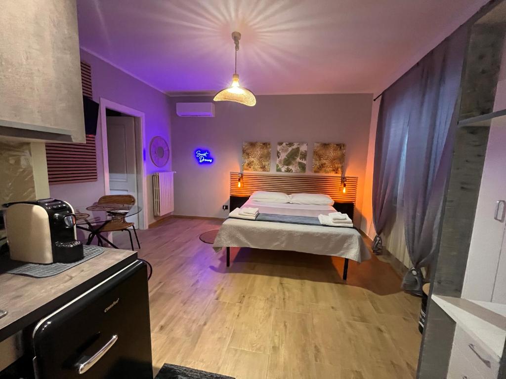 ein Schlafzimmer mit einem Bett in einem Zimmer mit lila Beleuchtung in der Unterkunft Nel giardino segreto in San Giorgio a Liri