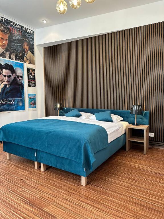 a bedroom with a large bed with a blue blanket at PostersApt3-Cozy Cinema Vibes in Vienna
