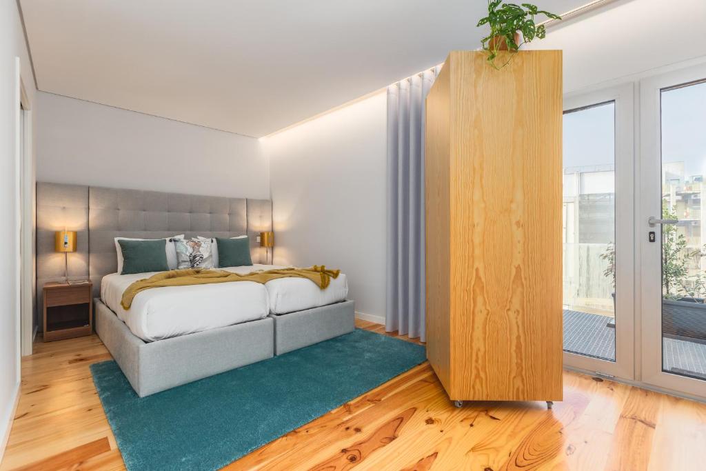 Un dormitorio con una cama y una ventana grande. en Urban Oasis Six Suites Apts Porto, en Oporto
