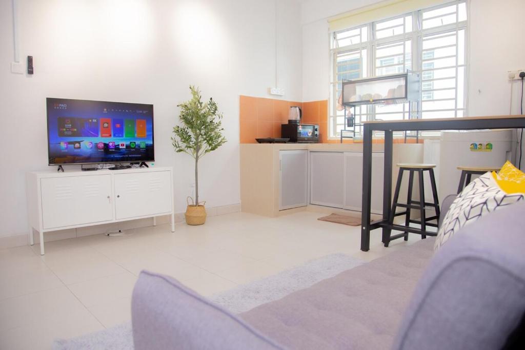 ein Wohnzimmer mit einem großen TV und einer Küche in der Unterkunft 5min walk to Tebrau ÆON Mall 1-5pax Free Netflix in Johor Bahru