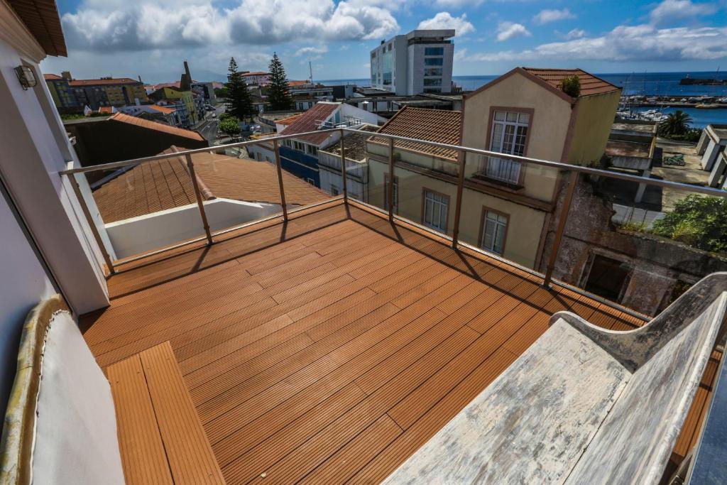a balcony with a wooden deck on a building at Flor do Mar House in Ponta Delgada