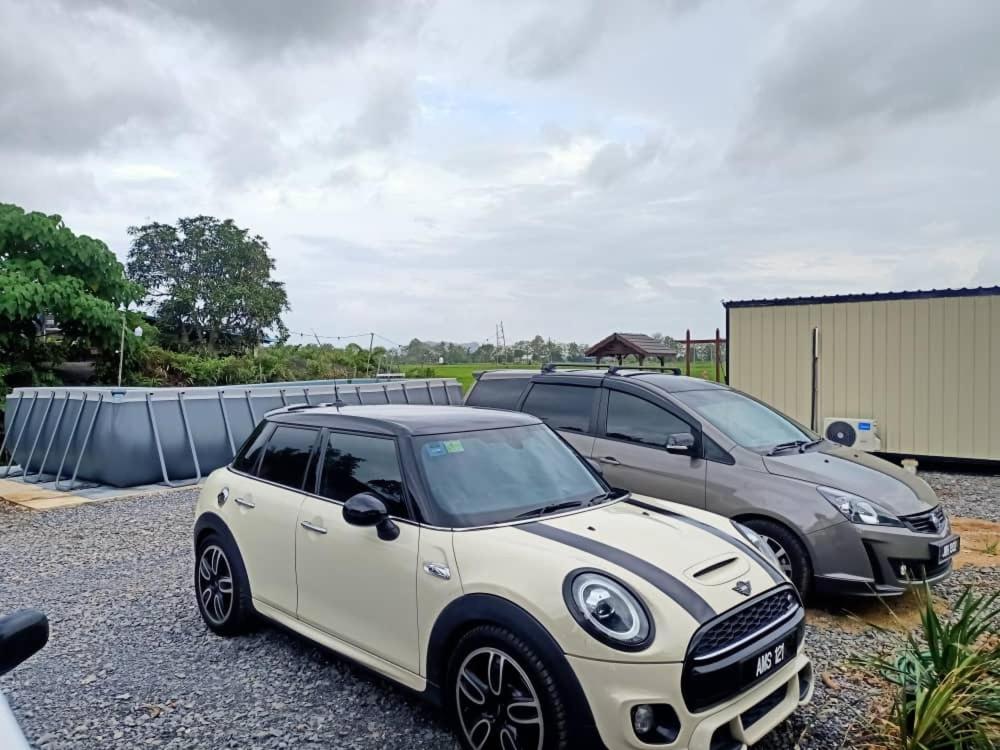 two cars are parked in a parking lot at Chinta Chinta Cottage Chalet Kayu in Arau