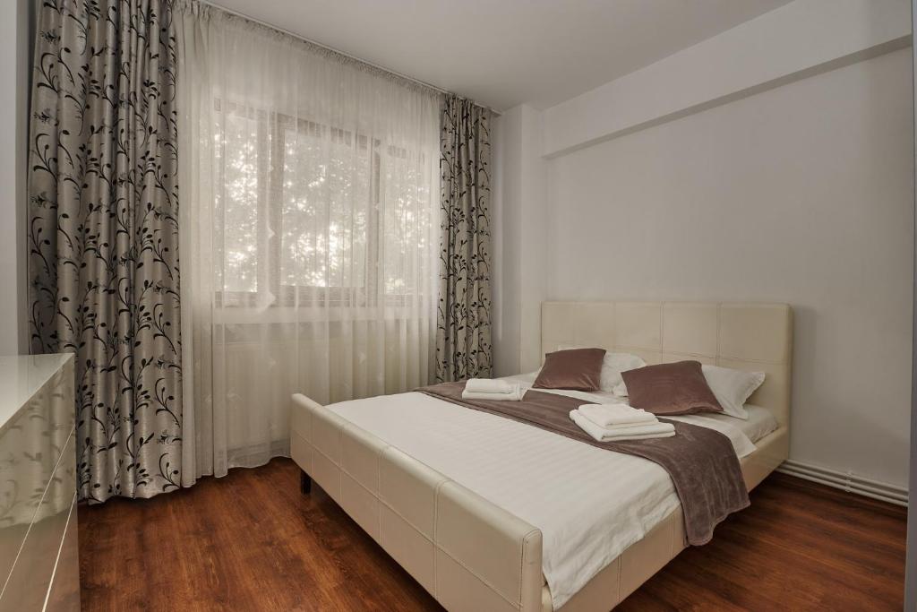 a bedroom with a white bed with a window at Konstanzer Podu Ros 2 - 3 camere, bucatarie, aer conditionat, masina de spalat in Iaşi