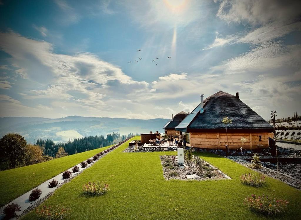 a log cabin on a hill with a green field at Heavenly Houses - Niebiańskie Domki in Jaworzynka